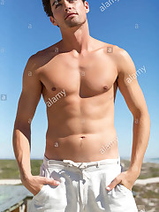 Shirtless man standing with mitts in